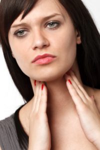 woman holding thyroid throat